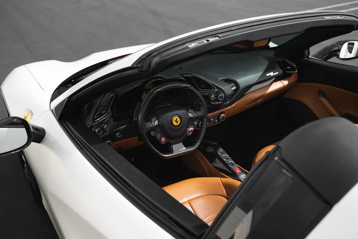 Ein offener Sportwagen mit hellbraunem Lederinterieur und Sportlenkrad
