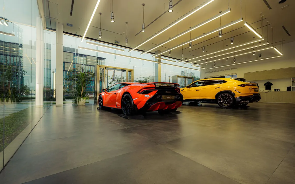 Orange und gelbe Sportwagen in einem hellen Showroom mit Glasfront